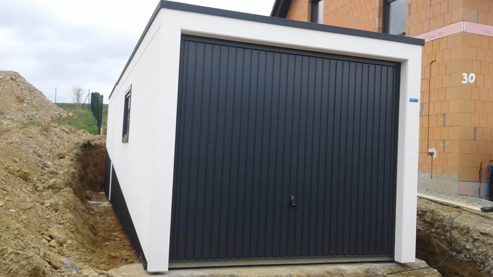 Betongarage am Hang mit Schwingtor