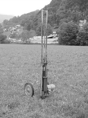 Kleiner fahrbarer Bohrmast auf einer Wiese, historische Aufnahme